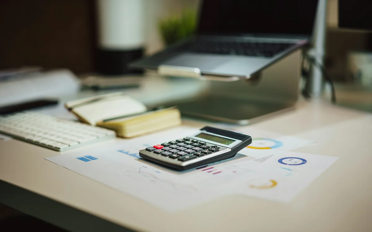 Calculadora y documentación de trabajo financiero.